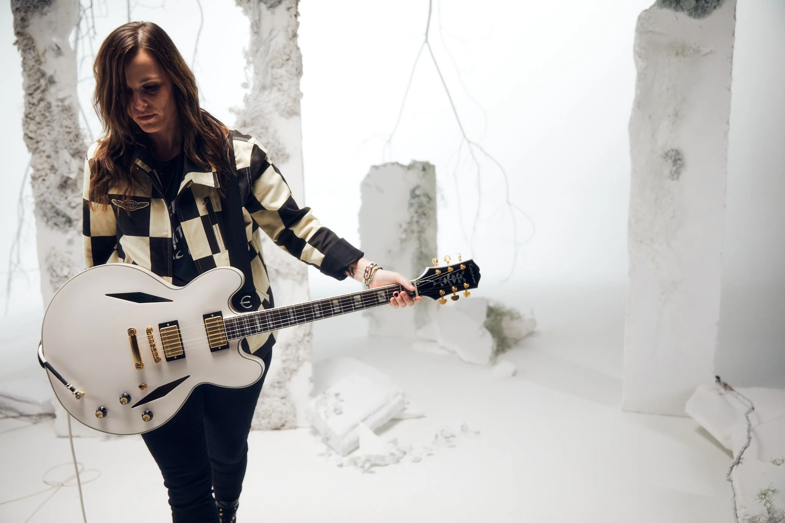 Emily Wolfe holding her white Epiphone Sheraton signature guitar
